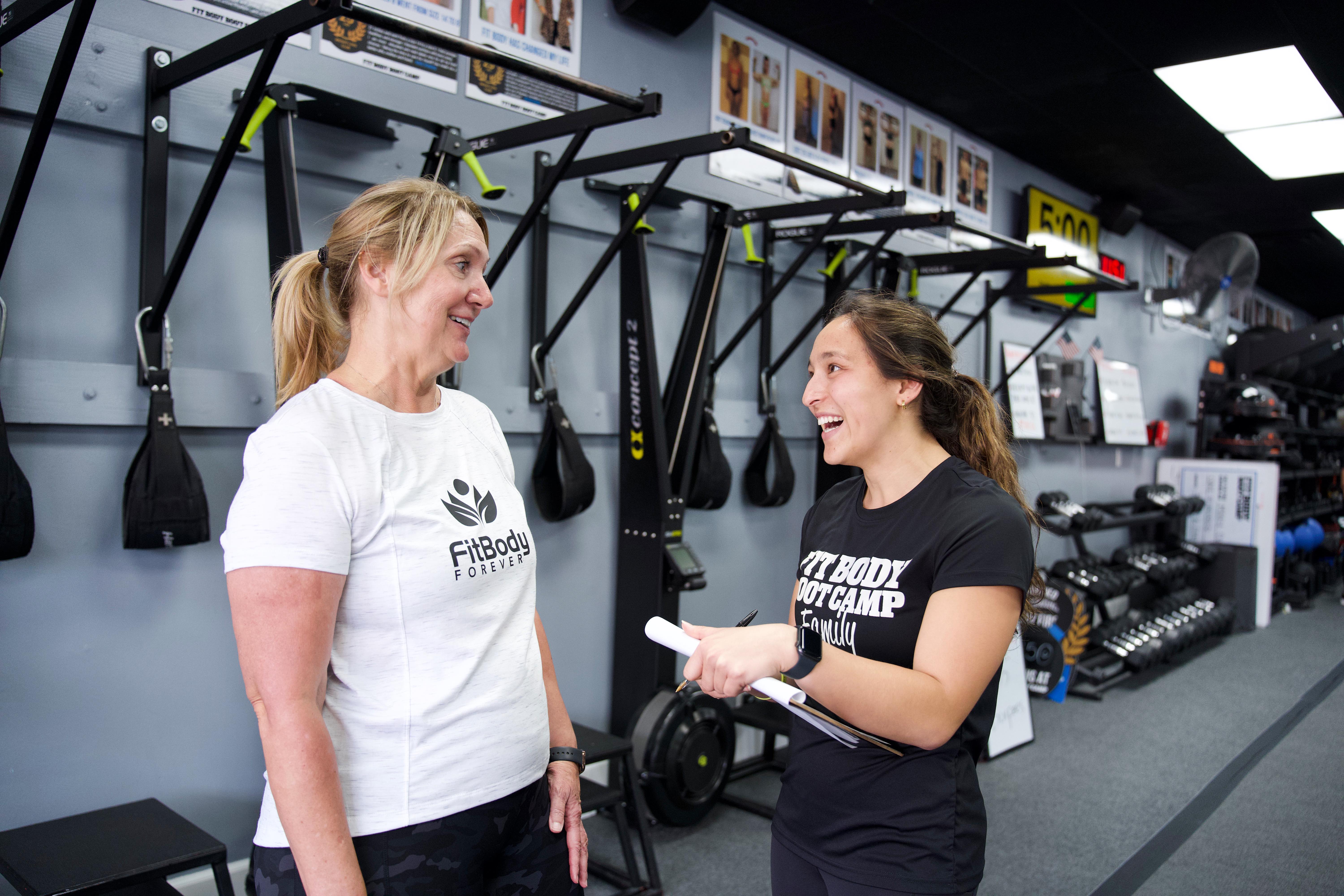 A Fit Body Forever coach encouraging a smiling member during a session