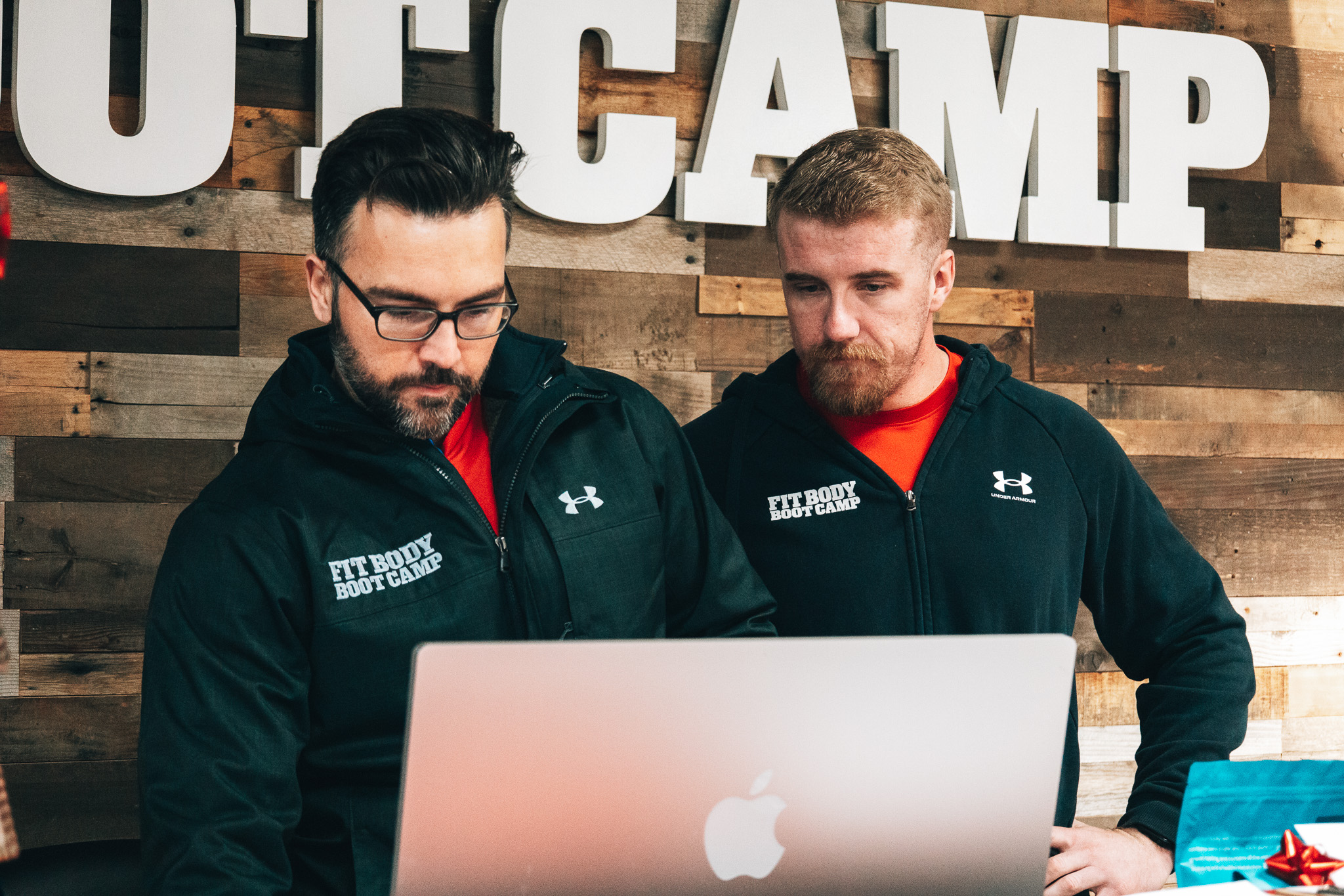 Two Fit Body coaches reviewing plans together on a laptop