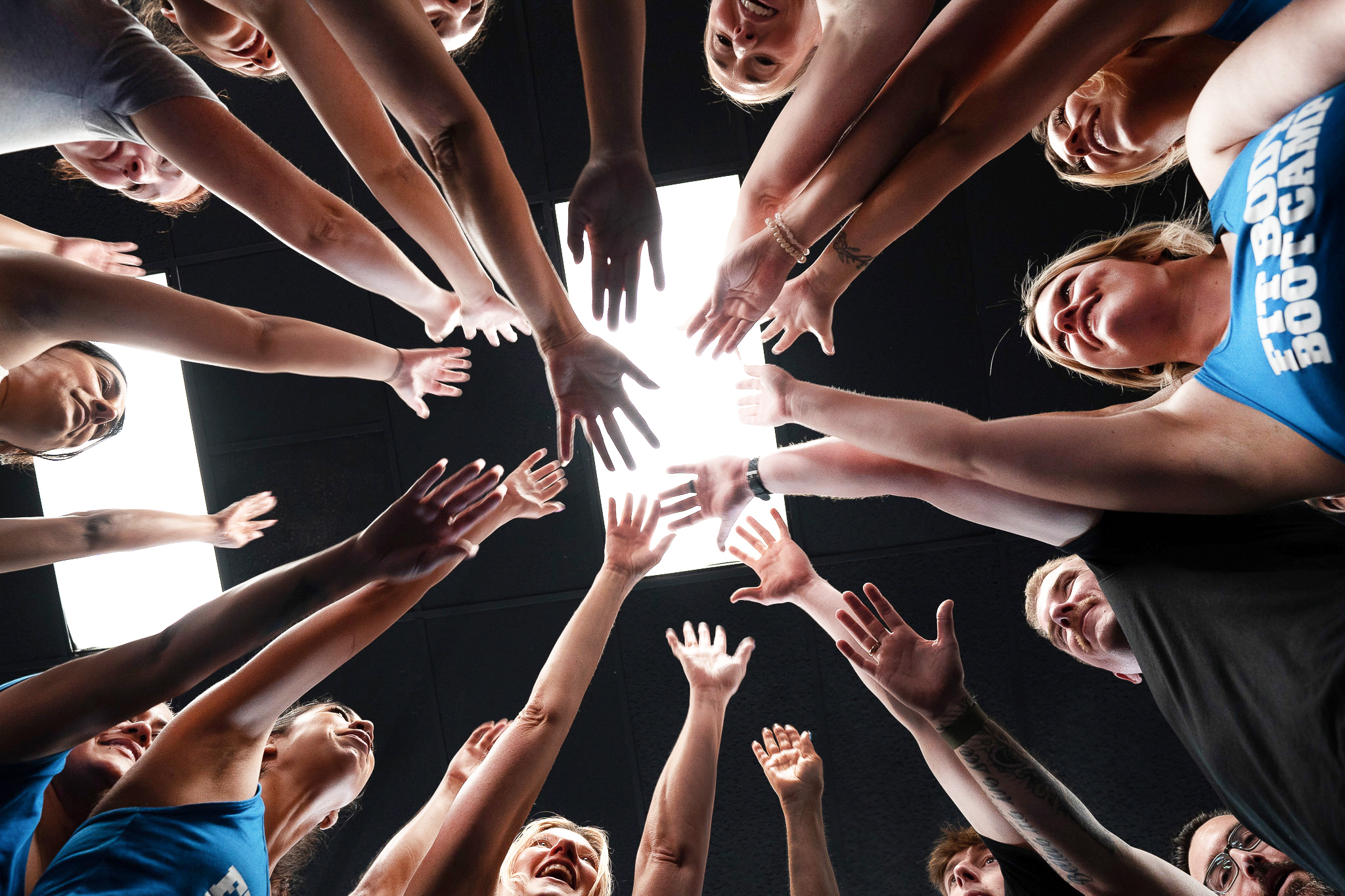 Fit Body Forever members putting their hands together in a team huddle
